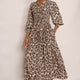 Model wearing a snake leopard print midi dress with a smocked bodice and sandals.