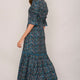 Side profile of model in the teal confetti midi dress.