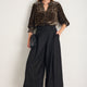 Full length shot of woman in Alina leopard blouse and black culottes