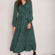 Model wearing a forest green polka dot midi dress with a belted waist