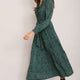 Side view of model wearing the forest green spot print midi dress