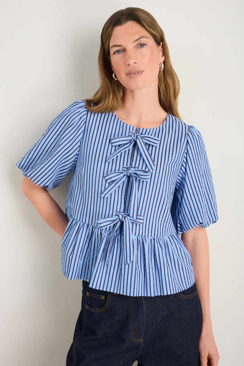 Front view of blue striped top with bow details