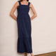 Front view of woman wearing midnight blue seersucker midi dress with wide scallop-edged straps