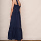 Rear three-quarter view showing the midi length and tiered hem of the midnight blue dress