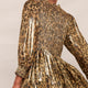 Full length view of a model in a metallic leopard print dress showing the fit.