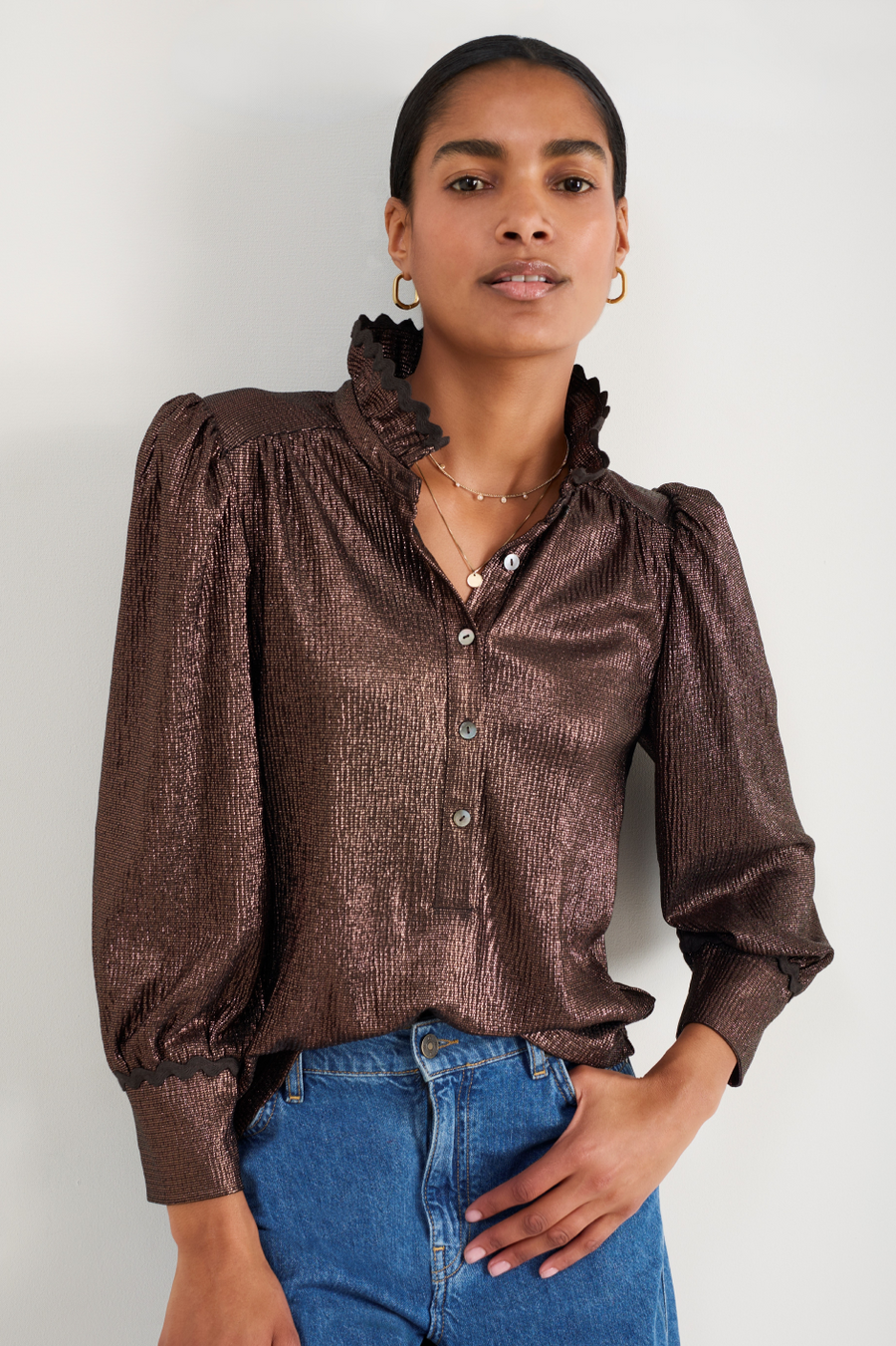 Close-up of the cocoa metallic top showing the frill collar and buttons.