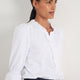 Close up of white blouse collar featuring broderie and frill trim.