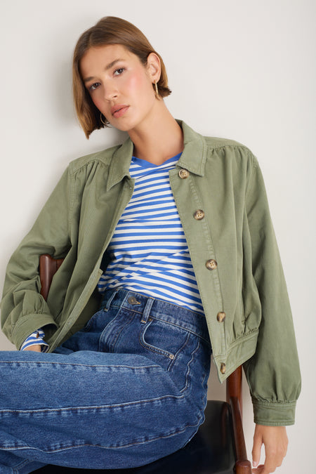 Model in a striped jersey top wearing a khaki jacket