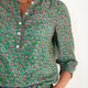 Close-up of the blouse collar and button detailing.