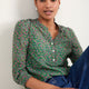 Model wearing a jade green floral print blouse with 3/4 length sleeves.