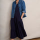 Model in navy midi dress layered with denim jacket