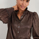 Detail of the sleeve and cuff of the metallic cocoa blouse.